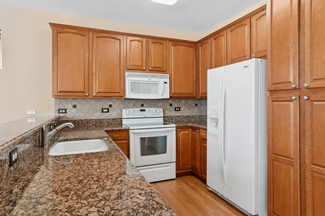 a kitchen with a refrigerator sink and cabinets