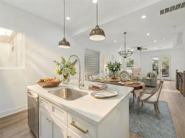 a kitchen with a sink a counter space appliances and cabinets