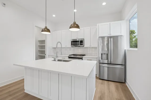 a kitchen with stainless steel appliances a refrigerator sink and microwave