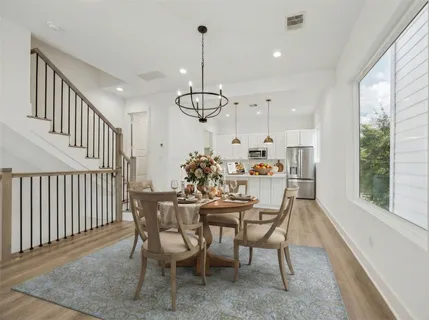 a view of a dining room and livingroom with furniture wooden floor a chandelier