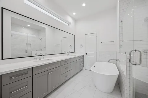 a spacious bathroom with a granite countertop sink mirror and bathtub