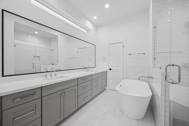 a spacious bathroom with a granite countertop sink mirror and bathtub