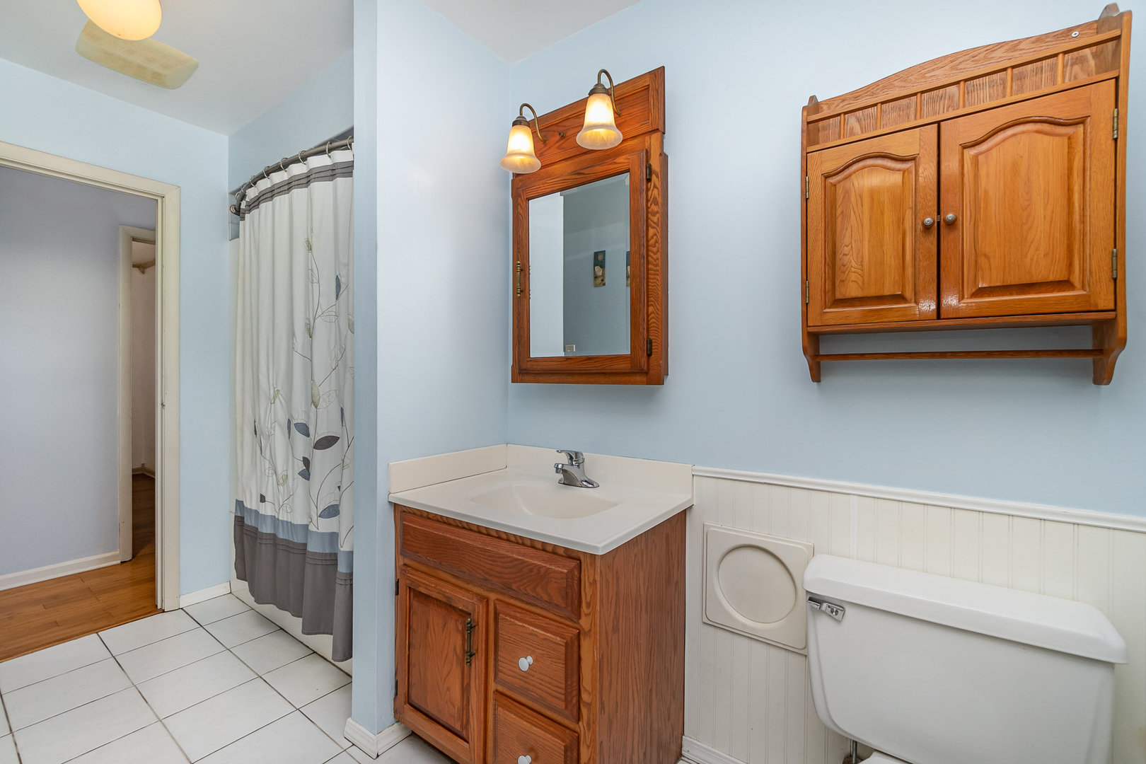 2831 193rd Street Lansing, IL 60438 - Photo 10 of 28 a bathroom with a sink a mirror and a shower