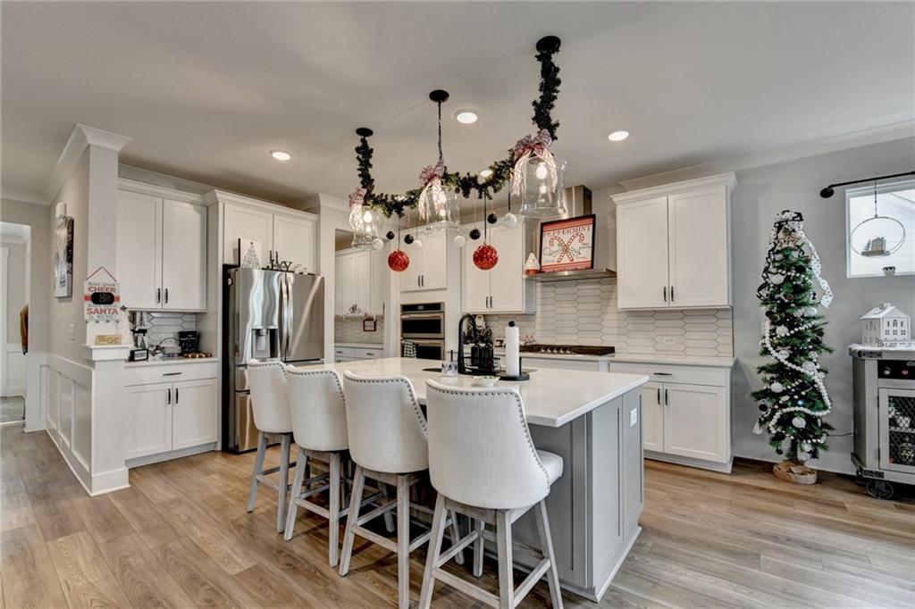 572 Redfish Way Hoschton, GA 30548 - Photo 16 of 67 a kitchen with white cabinets and white appliances