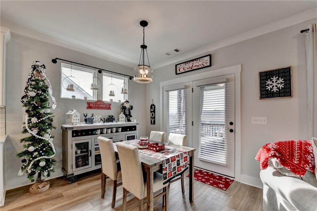 572 Redfish Way Hoschton, GA 30548 - Photo 21 of 67 a view of a dining room with furniture window and wooden floor