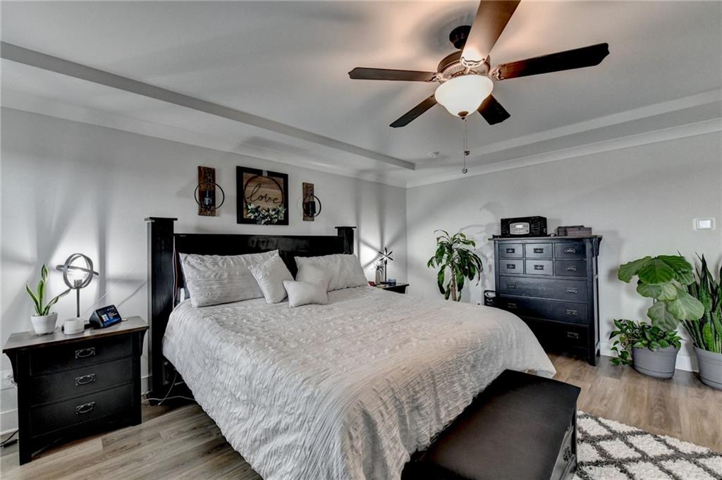 572 Redfish Way Hoschton, GA 30548 - Photo 29 of 67 a bedroom with bed and a chandelier