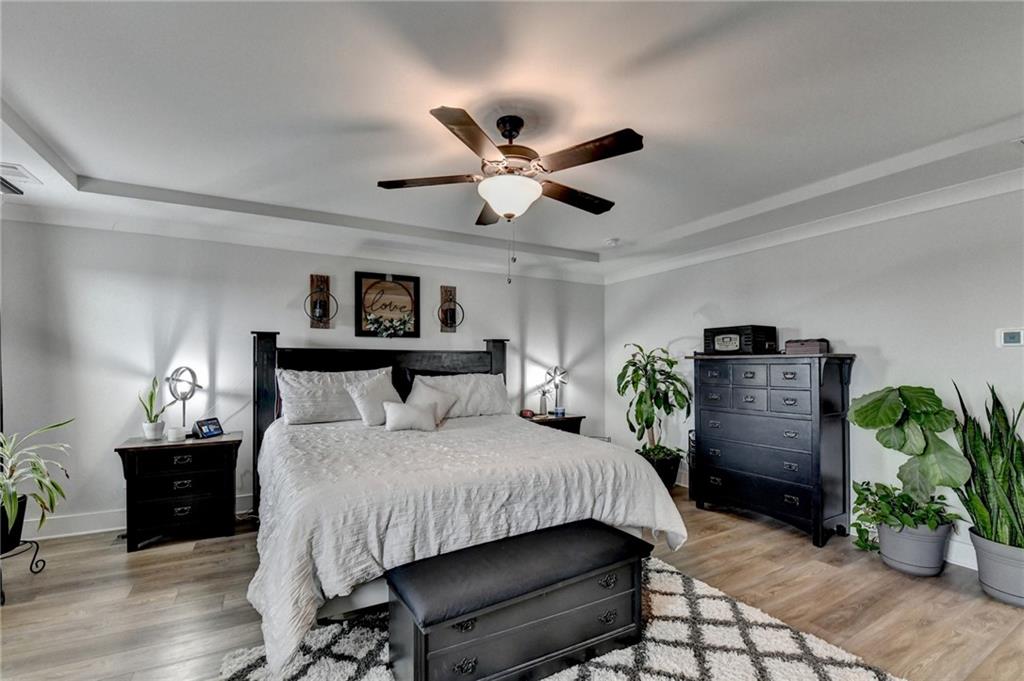 572 Redfish Way Hoschton, GA 30548 - Photo 30 of 67 a bedroom with a bed potted plant and a ceiling fan
