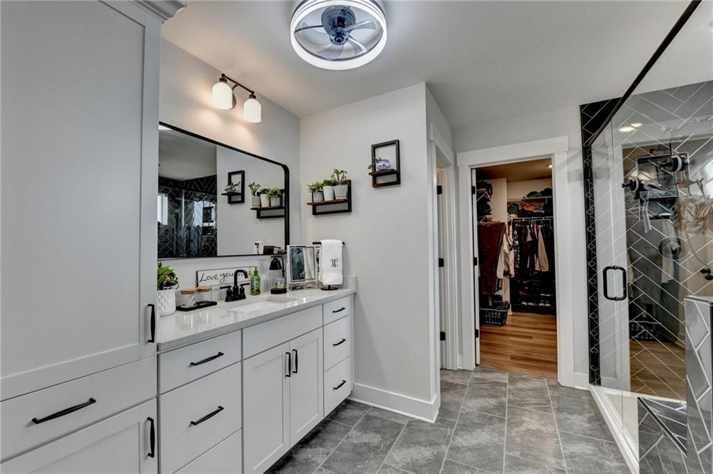 572 Redfish Way Hoschton, GA 30548 - Photo 32 of 67 a spacious bathroom with a double vanity sink and a mirror
