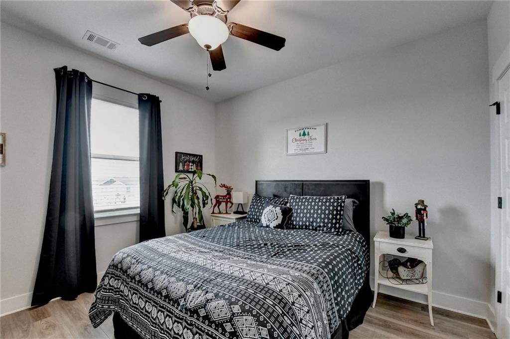 572 Redfish Way Hoschton, GA 30548 - Photo 37 of 67 a bedroom with a bed and a chandelier