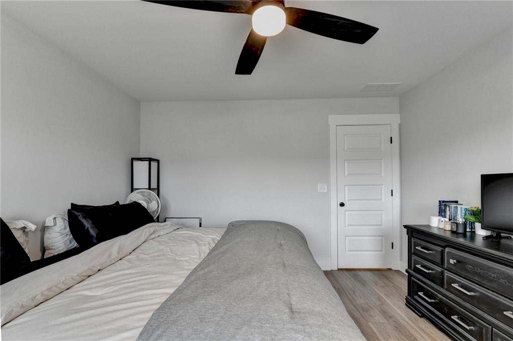 572 Redfish Way Hoschton, GA 30548 - Photo 46 of 67 a bedroom with a bed and wooden floor