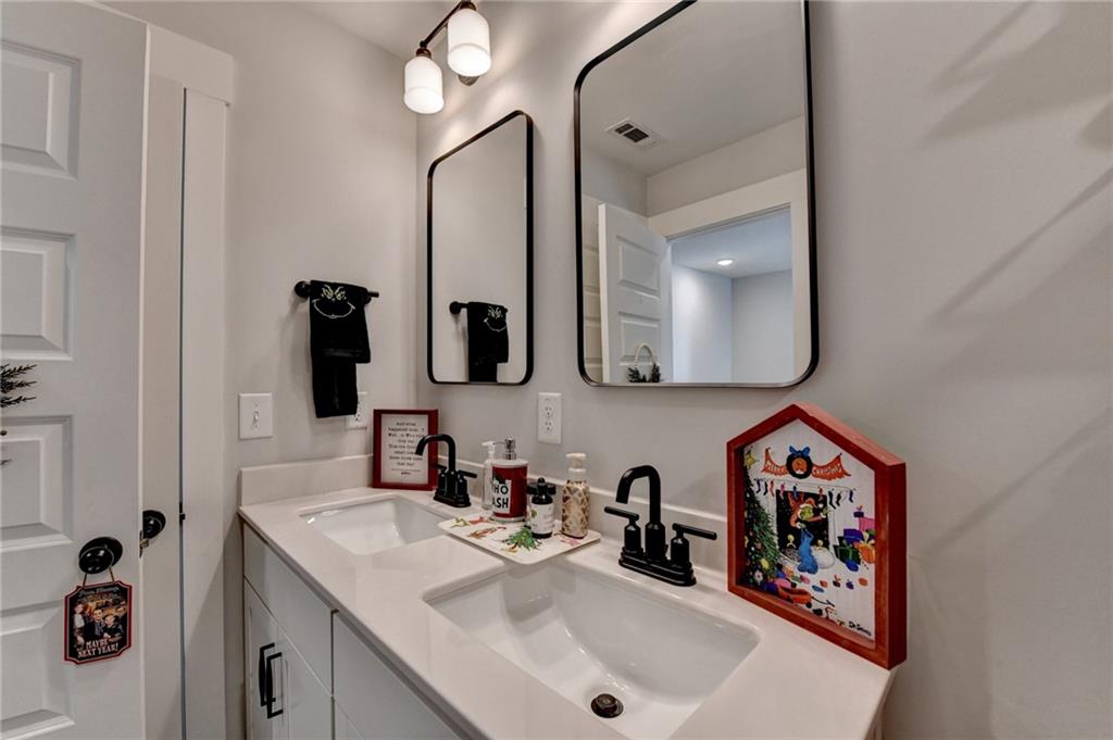 572 Redfish Way Hoschton, GA 30548 - Photo 48 of 67 a bathroom with double vanity sink and a mirror