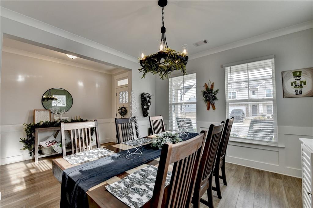 572 Redfish Way Hoschton, GA 30548 - Photo 8 of 67 a view of a dining room with furniture a chandelier and wooden floor