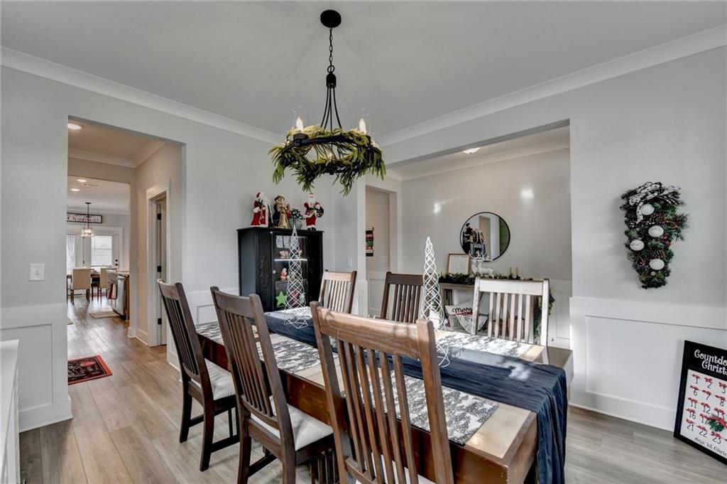 572 Redfish Way Hoschton, GA 30548 - Photo 9 of 67 a view of a dining room and livingroom with furniture wooden floor a chandelier