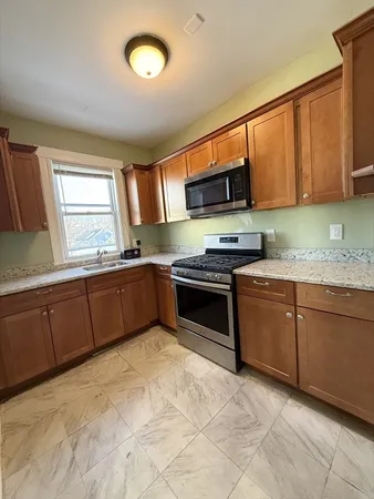 a kitchen with stainless steel appliances granite countertop a stove sink and cabinets