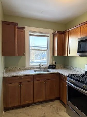 a kitchen with a sink stove top oven and cabinets