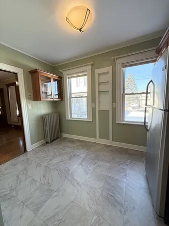 a view of an empty room with a window and a fireplace