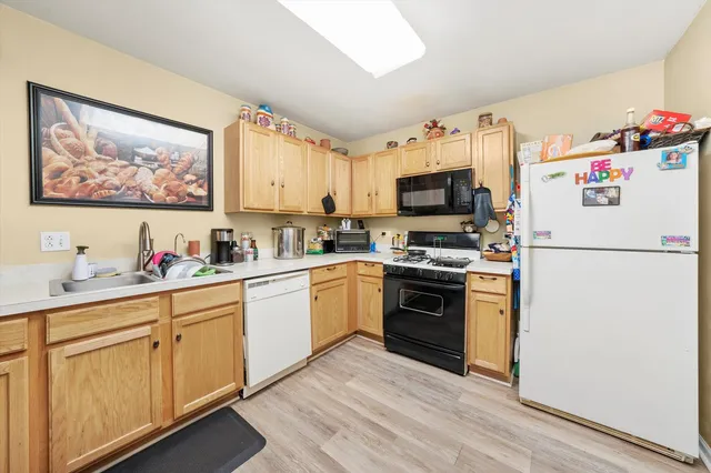 a kitchen with granite countertop white cabinets and stainless steel appliances
