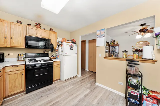 a kitchen with stainless steel appliances a stove top oven a refrigerator and a cabinets