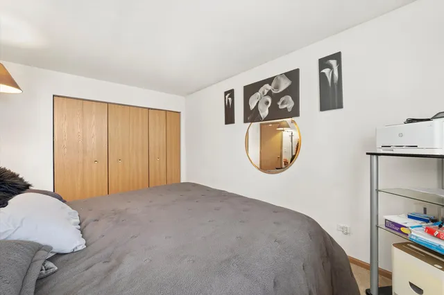 a bedroom with a bed and a painting on the wall