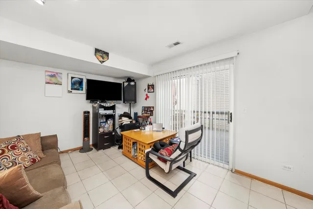 a living room with furniture a flat screen tv and a window