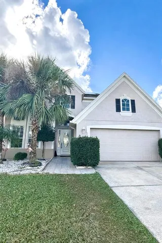 a front view of a house with a yard and potted plants