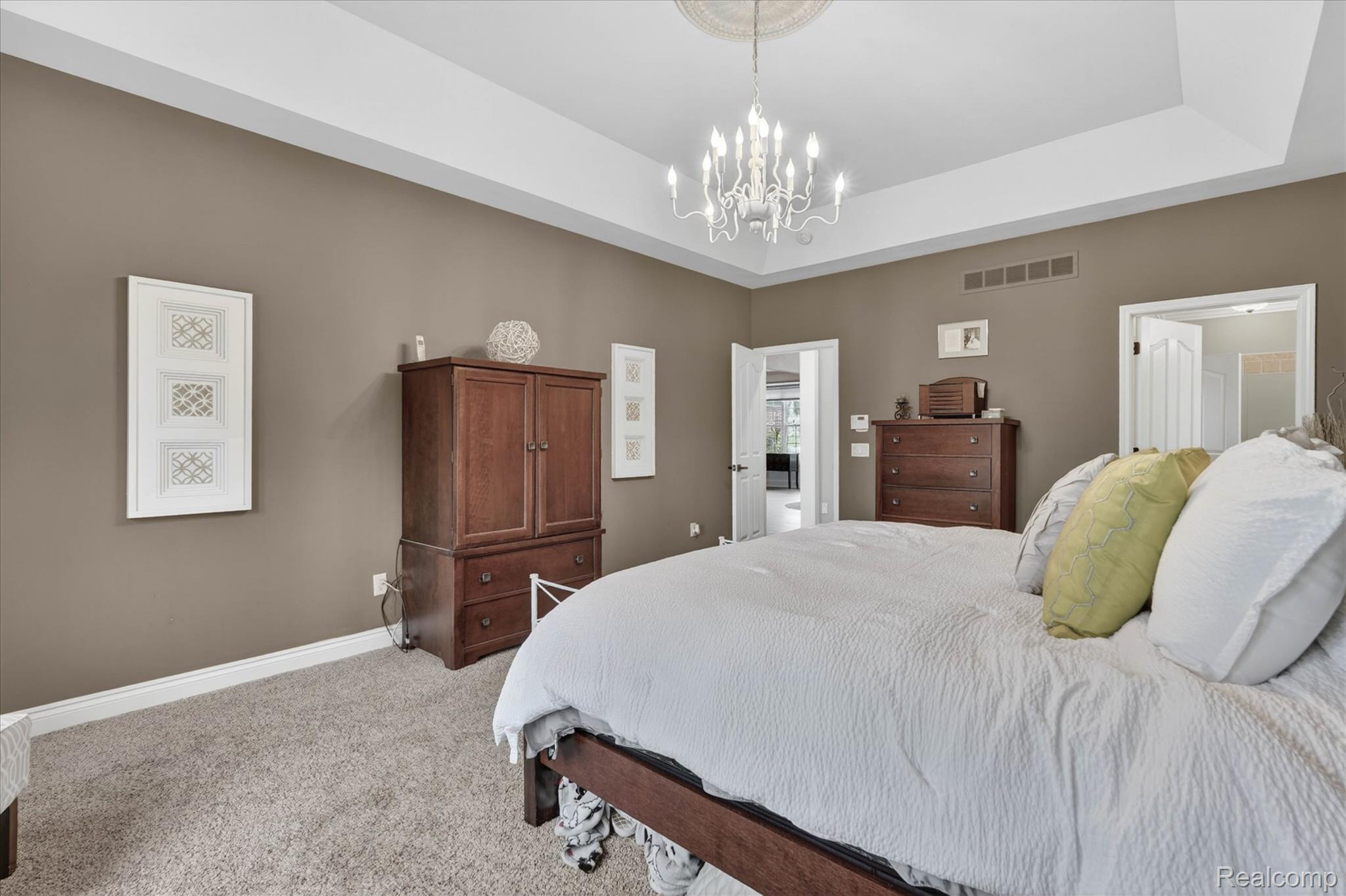 9074 Ridgefield Drive Brighton, MI 48114 - Photo 35 of 75 Bedroom with light carpet, suspended lighting, and a raised ceiling