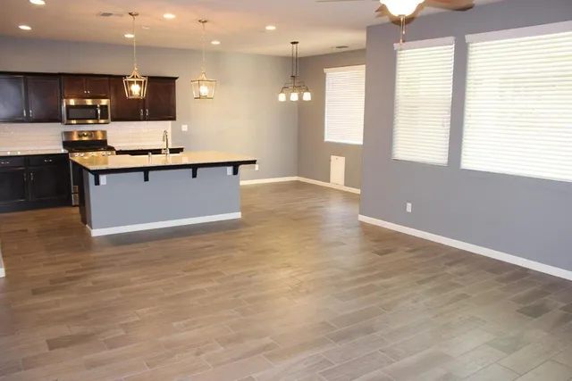 a view of kitchen with kitchen island granite countertop a stove and a large window