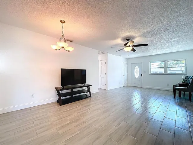 a view of an empty room with a mirror and wooden floor