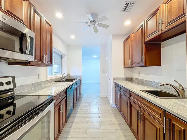 a kitchen with stainless steel appliances granite countertop a sink and a stove