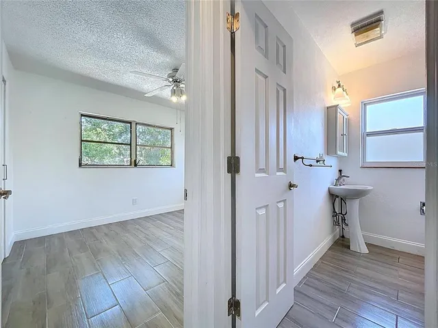 a bathroom with a tub a sink and wooden floor