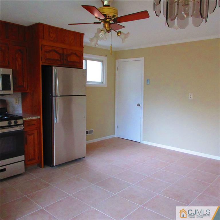 19 North Pennington Road New Brunswick, NJ 08901 - Photo 4 of 10 a view of a kitchen with a refrigerator and a ceiling fan