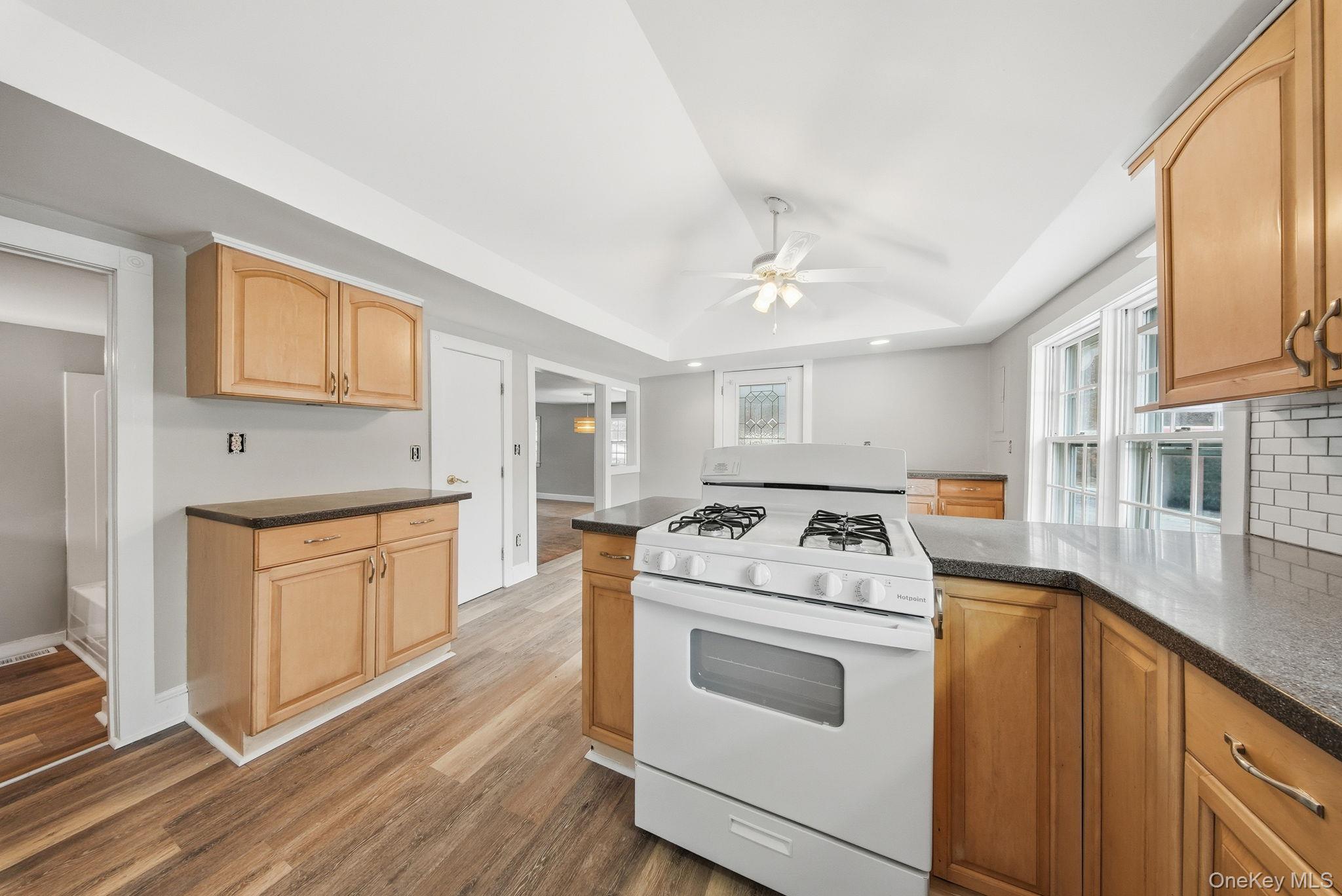 54 Lime Kiln Road Port Jervis, NY 12771 - Photo 27 of 34 a kitchen with a stove top oven a sink dishwasher and a refrigerator with wooden floor