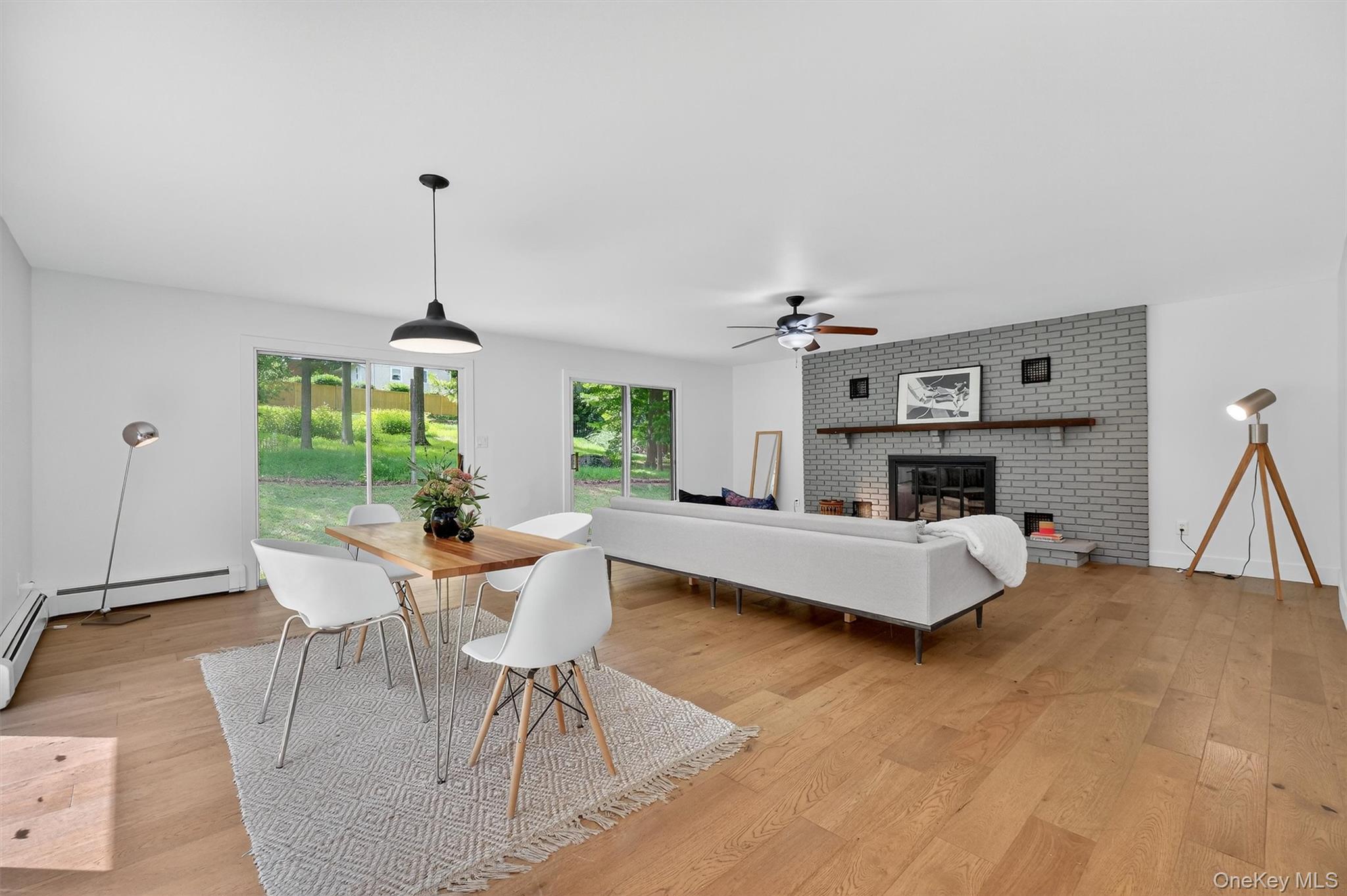 15 Fairview Road Beacon, NY 12508 - Photo 14 of 41 Dining area featuring a brick fireplace, light wood-type flooring, a baseboard heating unit, and ceiling fan