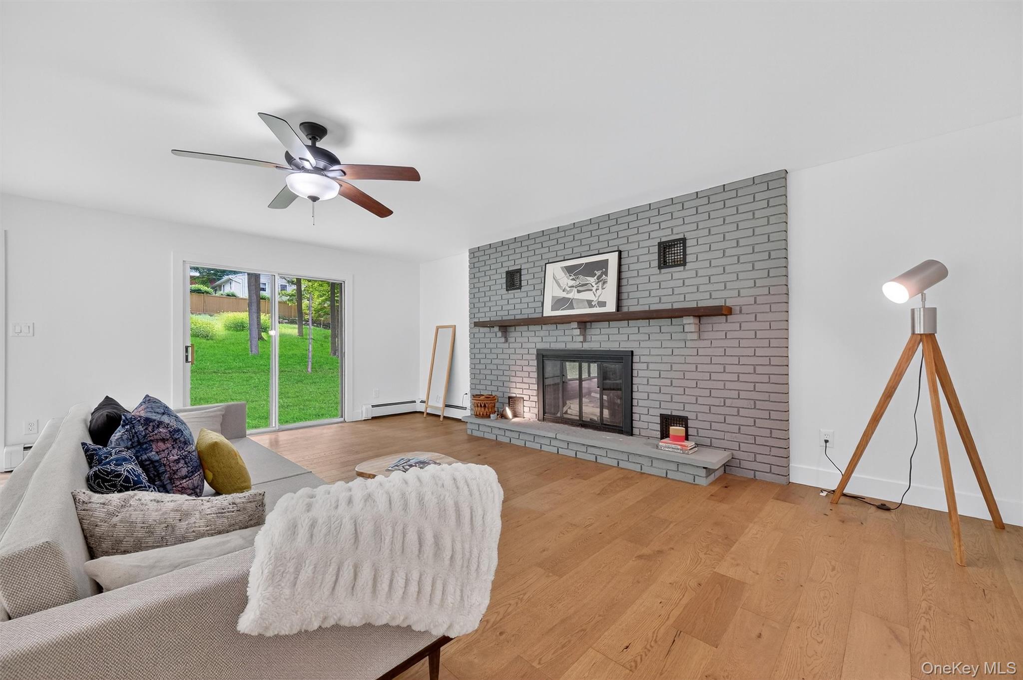 15 Fairview Road Beacon, NY 12508 - Photo 18 of 41 Living room featuring a brick fireplace, light wood finished floors, and a ceiling fan