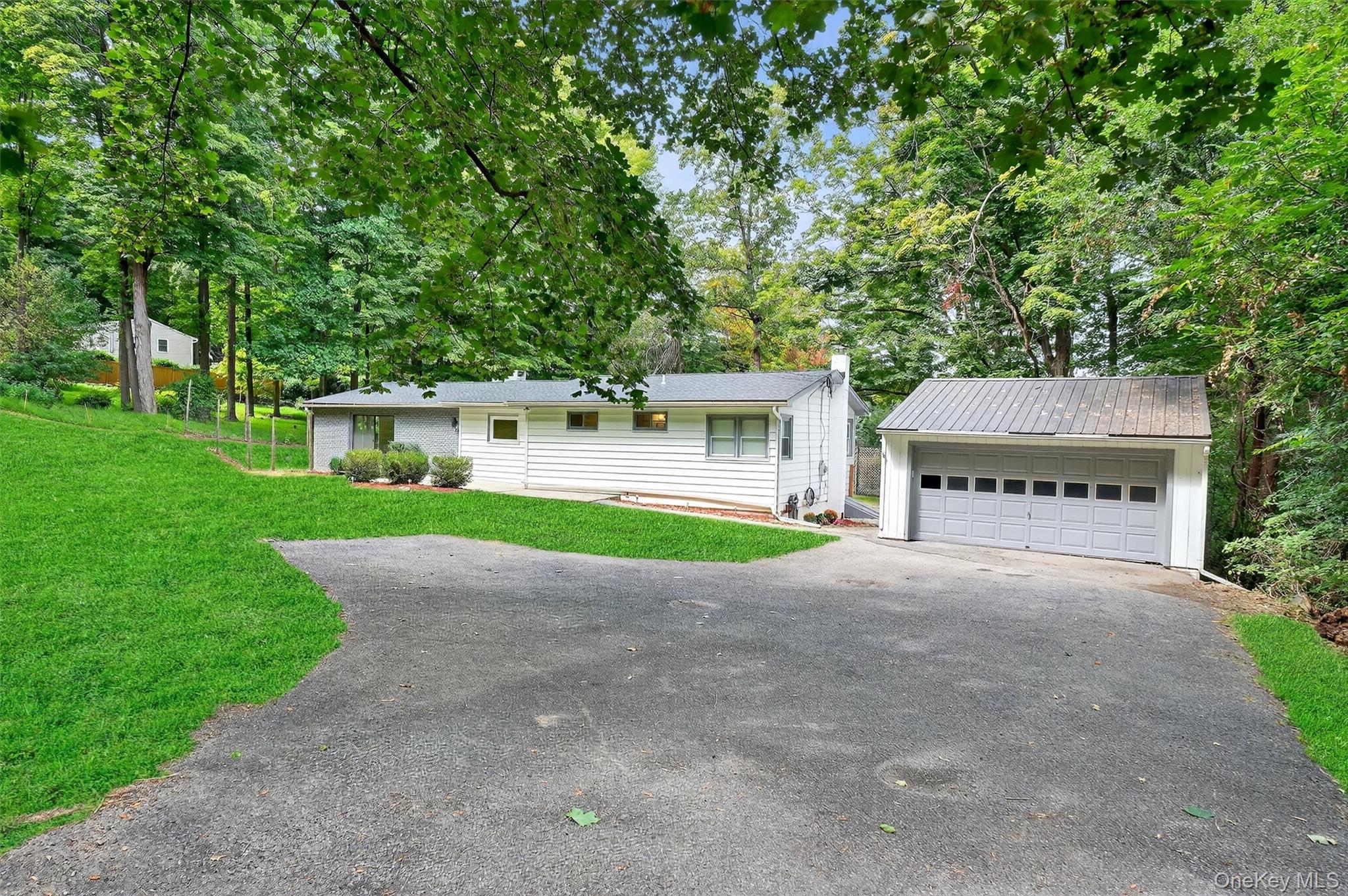 15 Fairview Road Beacon, NY 12508 - Photo 4 of 41 Single story home featuring a chimney, an outdoor structure, a front lawn, view of wooded area, and a garage
