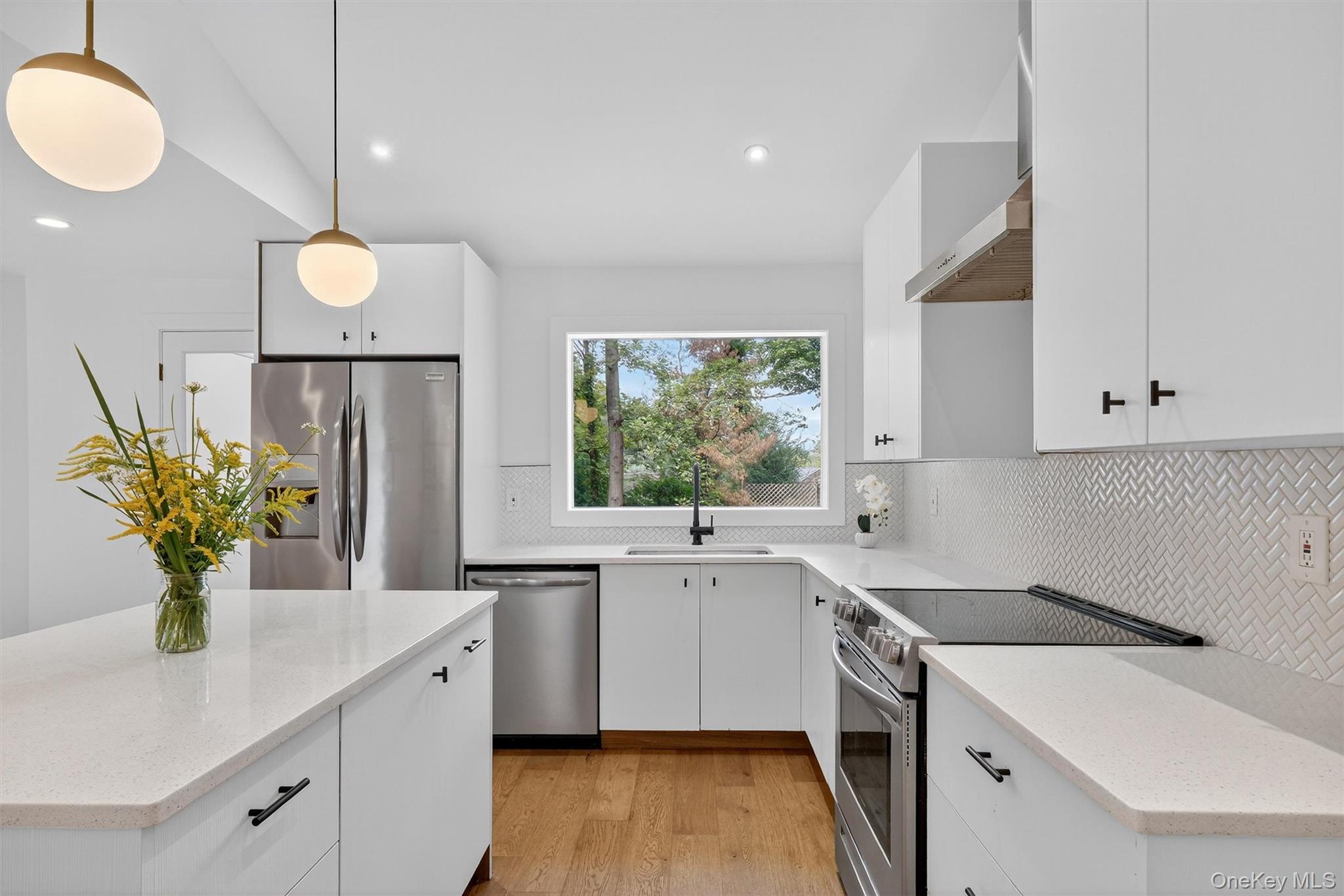 15 Fairview Road Beacon, NY 12508 - Photo 6 of 41 Kitchen with white cabinets, appliances with stainless steel finishes, light stone counters, light wood-style flooring, and backsplash