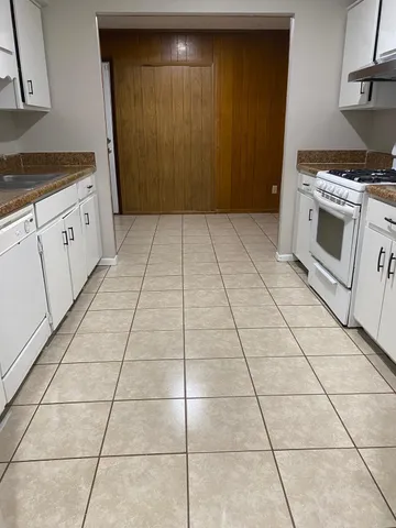 an empty room with windows and chandelier fan