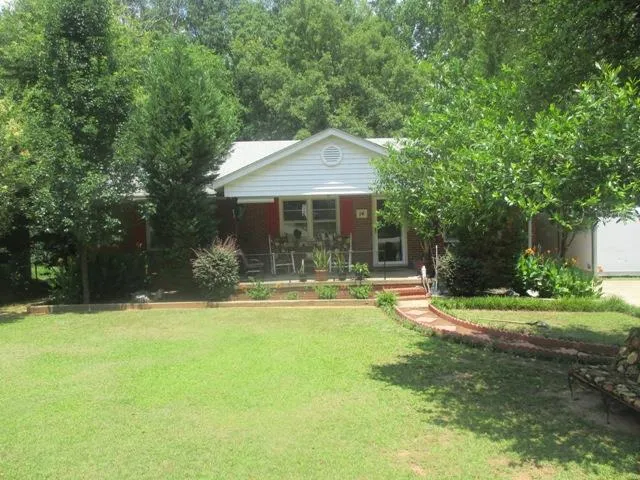 a front view of a house with a yard and trees