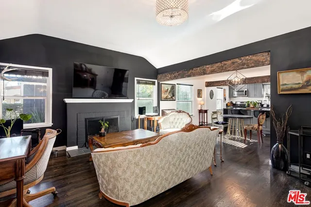 a kitchen with stainless steel appliances granite countertop a stove a sink a microwave a dining table and chairs with wooden floor