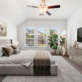 a spacious bedroom with a bed and a flat screen tv