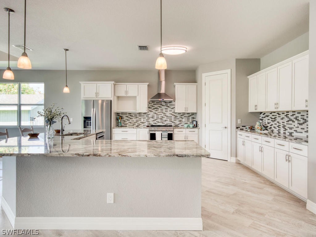 12523 River Road Fort Myers, FL 33905 - Photo 12 of 24 a kitchen with kitchen island a counter and a view of living room