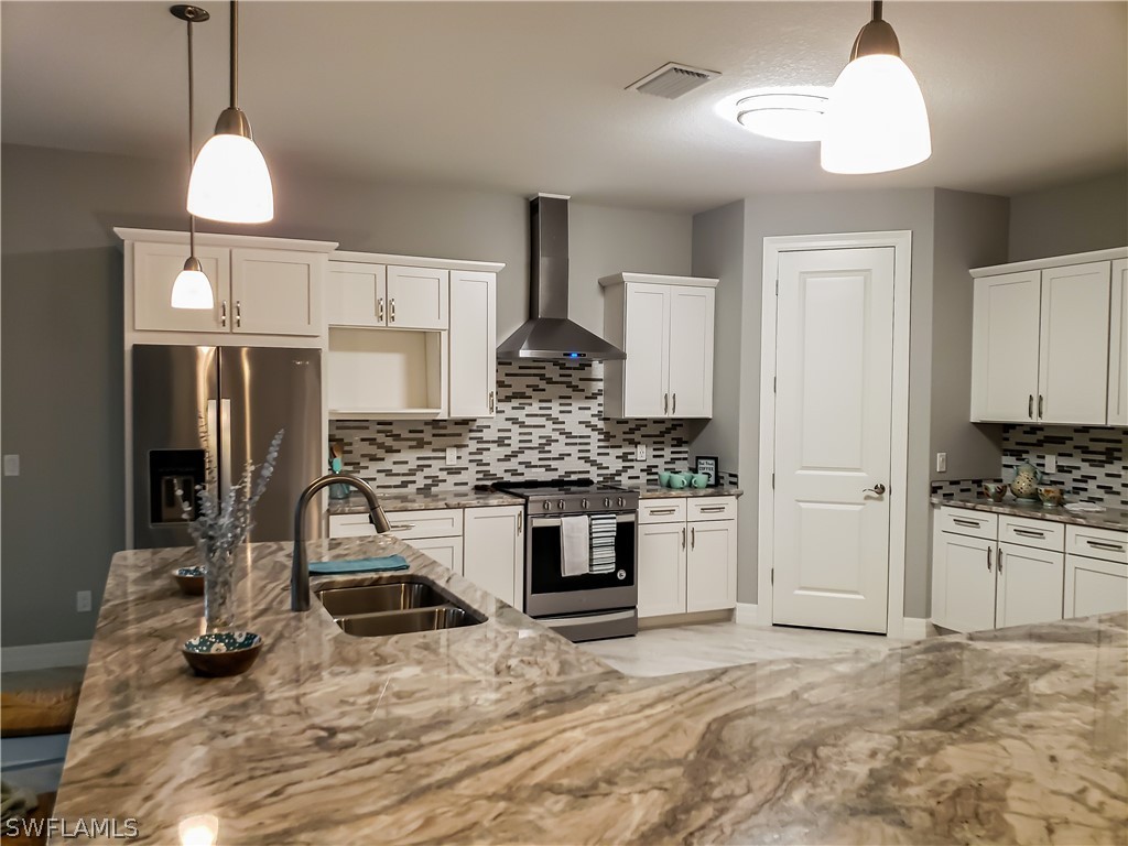 12523 River Road Fort Myers, FL 33905 - Photo 9 of 24 a kitchen with stainless steel appliances granite countertop a stove and a refrigerator