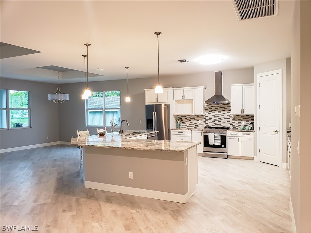 12523 River Road Fort Myers, FL 33905 - Photo 10 of 24 a view of a kitchen with kitchen island stainless steel appliances sink stove and cabinets