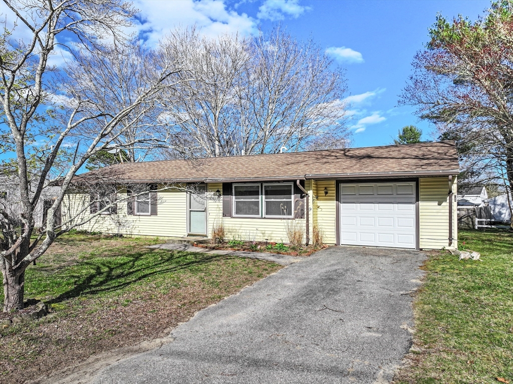 a front view of a house with a garden and yard
