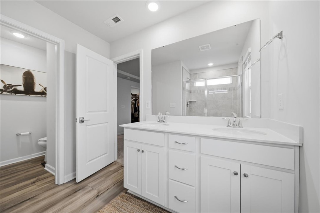 455 Bee Cv Way Pendleton, SC 29670 - Photo 26 of 46 This spacious bathroom offers a double vanity and a glass-enclosed shower, creating a bright and functional space.