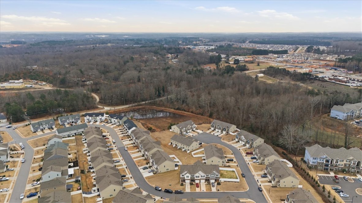 455 Bee Cv Way Pendleton, SC 29670 - Photo 38 of 46 An aerial perspective reveals a vibrant neighborhood nestled among wooded landscapes, featuring residential homes.