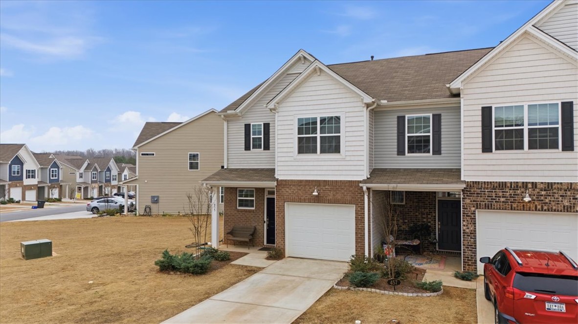 455 Bee Cv Way Pendleton, SC 29670 - Photo 43 of 46 This modern townhome features a charming brick facade, a spacious driveway, and an inviting front entry.