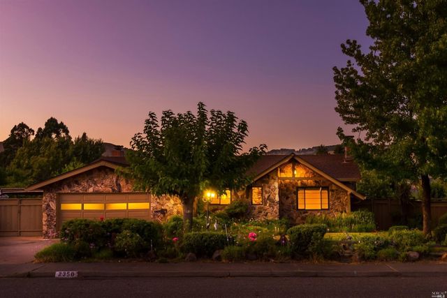 a view of a large trees in front of a house