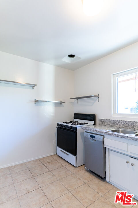 826 Hyperion Avenue Los Angeles, CA 90029 - Photo 16 of 25 a kitchen with stainless steel appliances granite countertop a stove a sink and a refrigerator