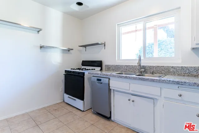 a kitchen with granite countertop white cabinets and white appliances